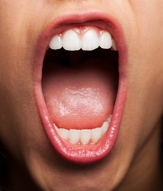 Close-up der jungen Frau zeigt ihre Zähne und Zunge