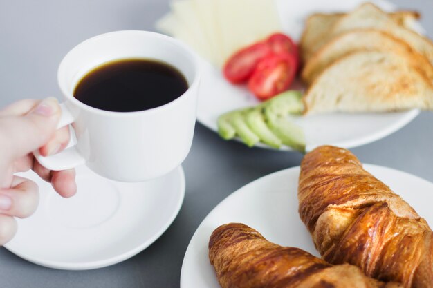 Close-up der Person mit Kaffee und Frühstück