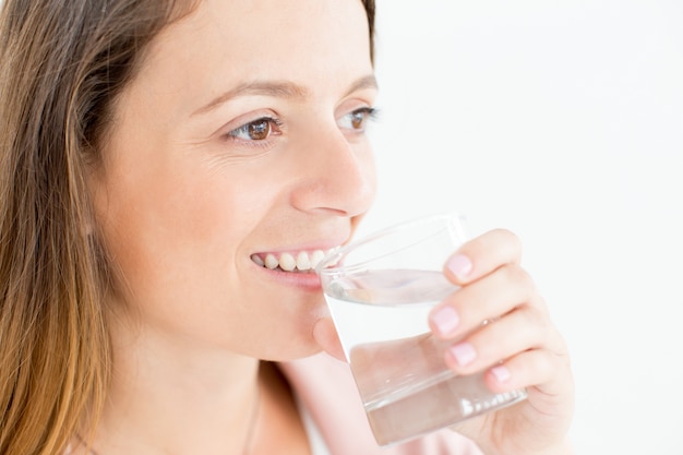 Close-up der positiven jungen Frau trinken Wasser
