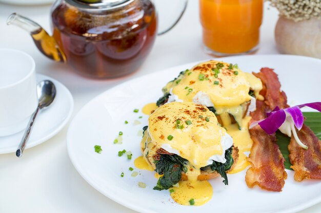 Close up frisches Ei Benedict Frühstück mit schwarzem Kaffee und Orangensaft