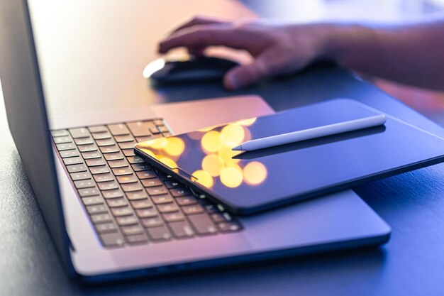 Close-up-Geschäftshand mit Stift und Stift arbeitet auf digitalem Tablet und Laptop
