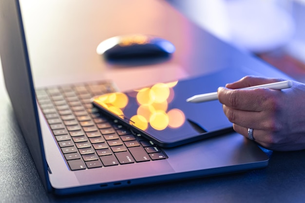 Close-up-Geschäftshand mit Stift und Stift arbeitet auf digitalem Tablet und Laptop