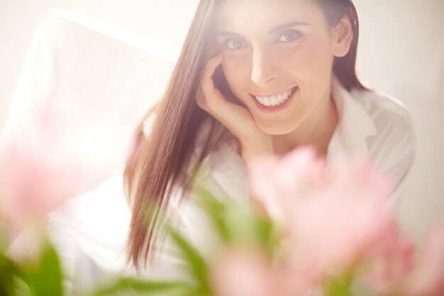 Close-up verwischt Blumen mit glücklichen Frau Hintergrund