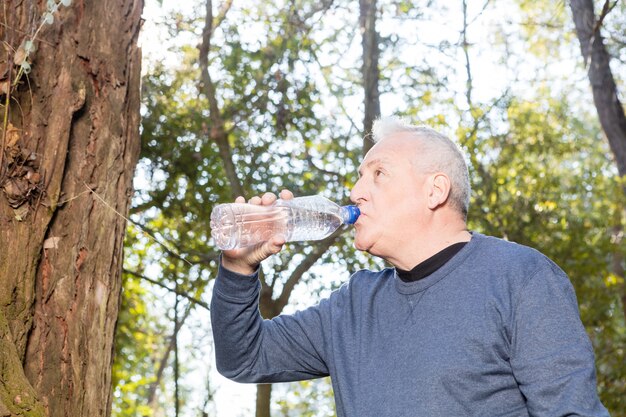 Close-up von durstigen Mann Trinkwasser nach dem Sport