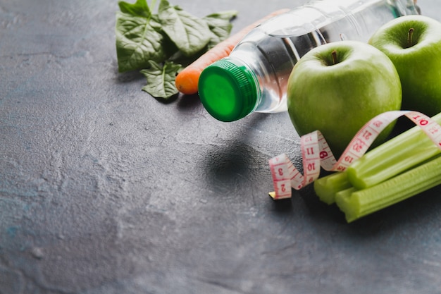 Close-up von gesunden Lebensmitteln mit Wasserflasche und Maßband