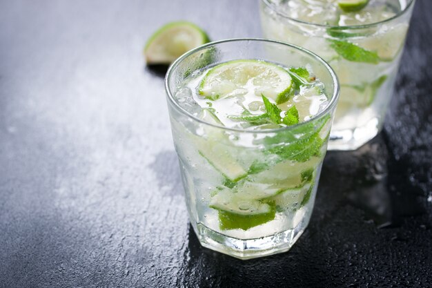 Close-up von Glas mit Zitronenscheiben und grüne Minze