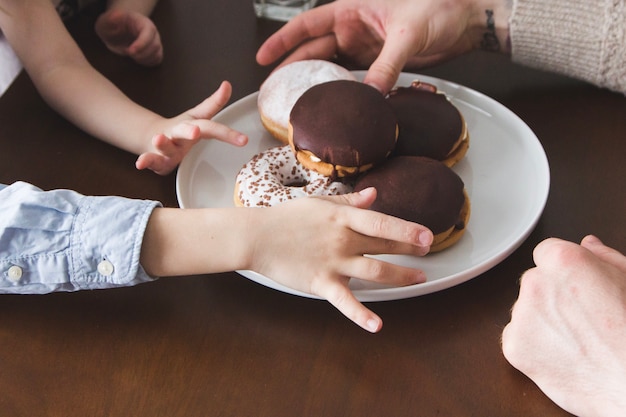 Kostenloses Foto close-up von händen kommissionierung donuts