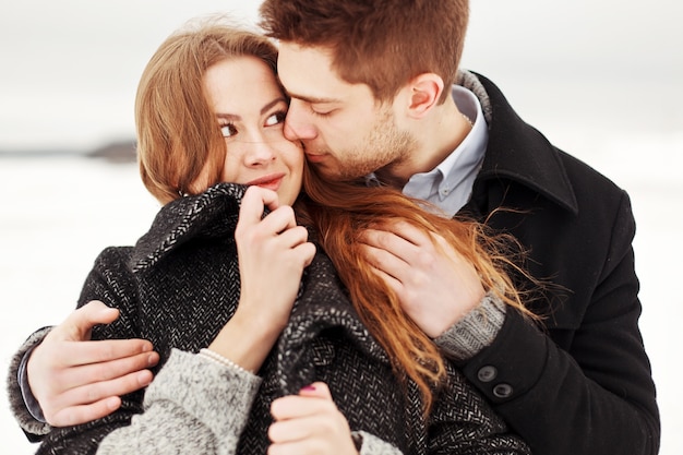 Close-up von leidenschaftlicher Mann die Wange von seiner hübschen Freundin küssen