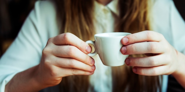 Closup von den Frauenhänden, die Kaffeetasse halten