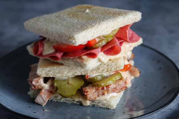 Club-Sandwich mit Fleisch, Rind und Huhn auf dem Tisch serviert.