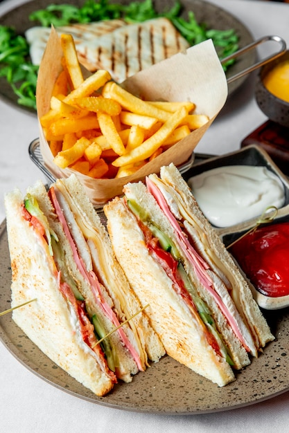 Club Sandwich serviert mit Pommes Frites Ketchup und Mayonnaise