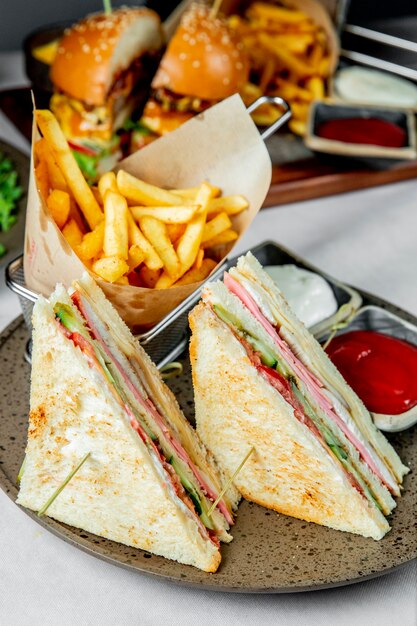 Club Sandwich serviert mit Pommes Frites Ketchup und Mayonnaise