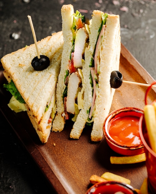 Club Sandwiches mit scharfer Chili Sauce und Pommes Frites.