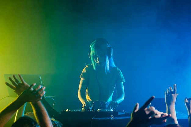 Clubbing mit einer DJ-Frau, die für die Menge mixt