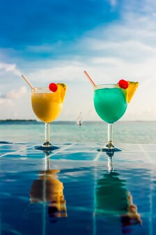 Cocktail in der nähe des swimmingpools auf dem hintergrund des indischen ozeans, malediven.