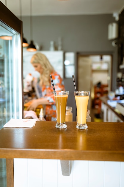 Kostenloses Foto cocktails auf bar mit kellnerin im hintergrund