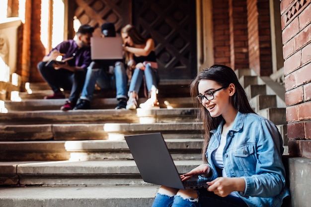 College-Mädchen, das nach dem Unterricht mit Laptop arbeitet