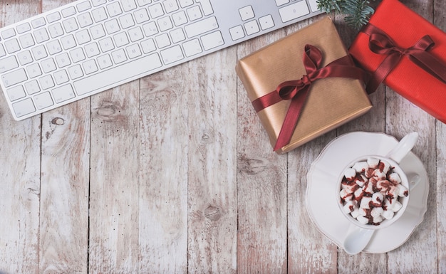Computer-Tastatur, Weihnachtsgeschenk und eine Tasse mit Marshmallows
