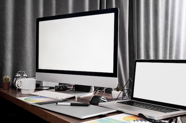 Computerbildschirm und Laptop-Gerät auf Büroarbeitsplatz