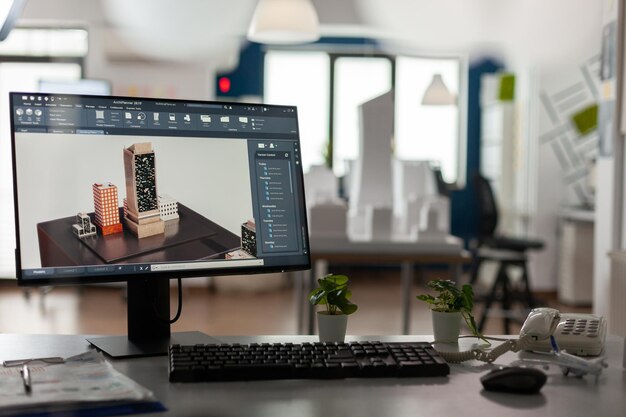 Computerdisplay mit 3D-Rendersoftware des architektonischen Gebäudekomplexes im modernen Architektenbüro. Desktop-Bildschirm auf dem Schreibtisch mit Bauplänen für Stadtplanungsarchitektur.