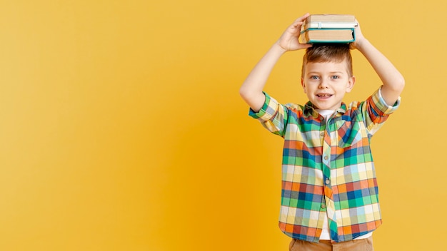 Copy-Space-Junge mit Büchern auf dem Kopf