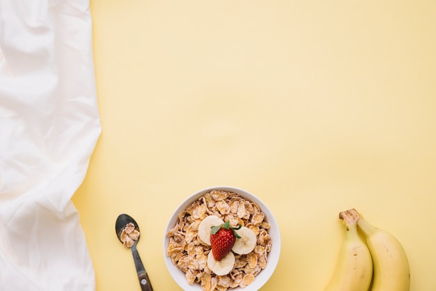 Kostenloses Foto corn flakes mit mit früchten in der schüssel auf tabelle