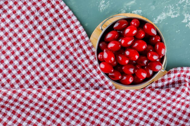 Cornel Beeren in einem Eimer mit Schneidebrett auf Gips und Picknicktuch