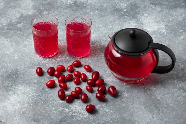 Cornels und roter Saft in Gläsern und Wasserkocher.