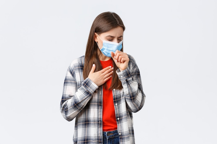 Kostenlose Foto coronavirus-ausbruch, freizeit in quarantäne, konzept der sozialen distanzierung und emotionen. frau in medizinischer maske, die hustet, sich krank fühlt, die lunge berührt, covid-19-symptome hat und krank ist.