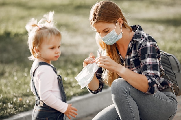 Coronavirus-Thema. Familie in einem Sommerpark. Frau in einem Zellenhemd.