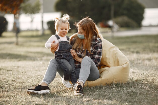 Coronavirus-Thema. Familie in einem Sommerpark. Frau in einem Zellenhemd.