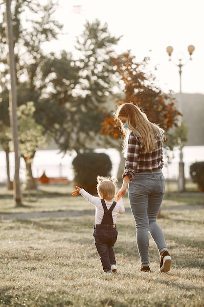 Coronavirus-Thema. Familie in einem Sommerpark. Frau in einem Zellenhemd.