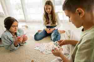 Kostenloses Foto cousins verbringen zeit zusammen zu hause und spielen karten