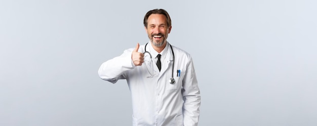 Covid-Coronavirus-Ausbruch im Gesundheitswesen und Pandemie-Konzept gutaussehender fröhlicher männlicher Arzt in