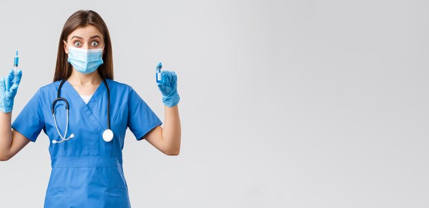 Covid19 verhindert Virus-Gesundheitspersonal und Quarantänekonzept Aufgeregte Krankenschwester in blauem Peeling Arzt in der Klinik mit Spritze und Ampulle mit Coronavirus-Impfstoff