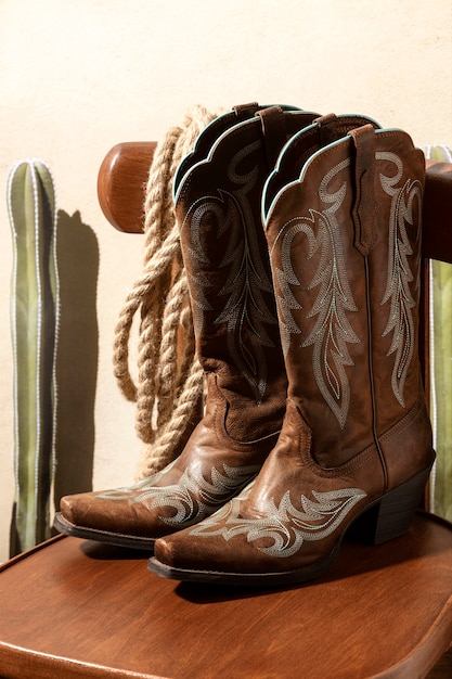 Kostenloses Foto cowboy-inspiration mit stiefeln auf dem stuhl