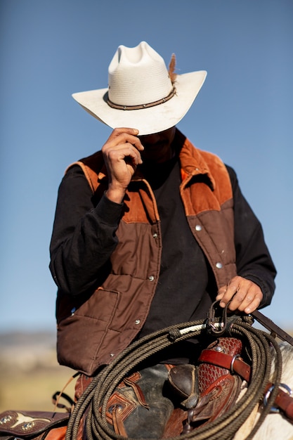 Kostenloses Foto cowboy-silhouette mit pferd gegen warmes licht