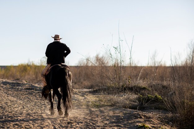 Cowboy-Silhouette mit Pferd gegen warmes Licht