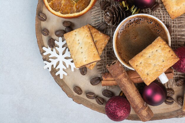 Cracker mit Aromatasse Kaffee auf Holzteller. Hochwertiges Foto