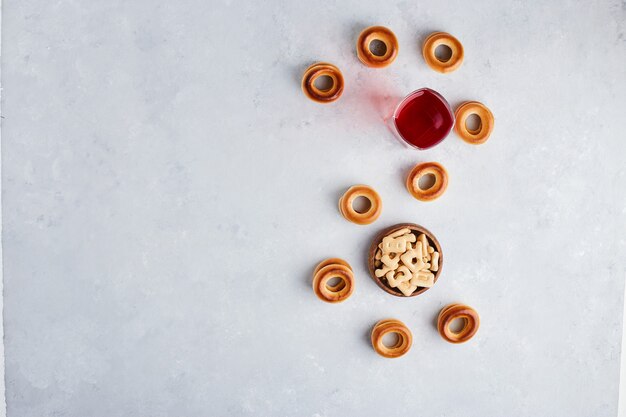 Cracker und Brötchen serviert mit einem Glas Saft, Draufsicht.