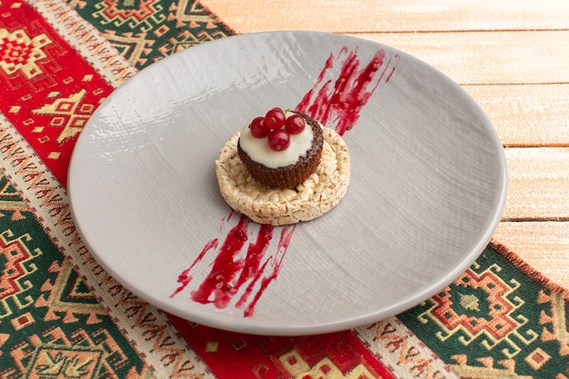 Cracker und Kuchen mit Preiselbeeren oben in lila Platte auf Creme rustikal