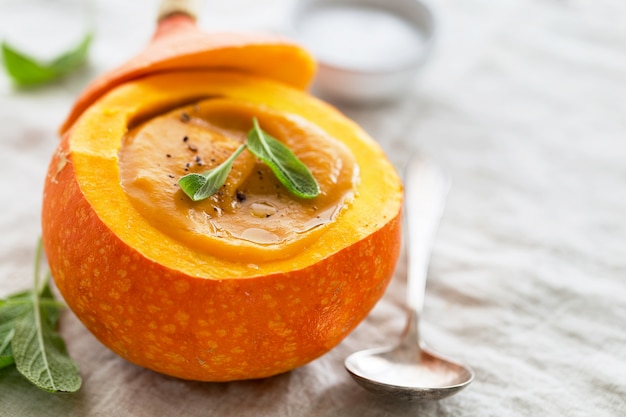 Cremige Kürbissuppe Püree in den ganzen Squash auf dem Tisch bereit zu essen