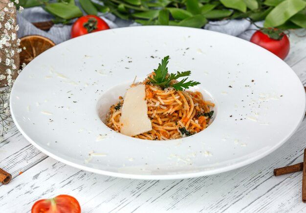 Cremige Möhrenspaghetti mit Tomaten, garniert mit Petersilie und Parmesan