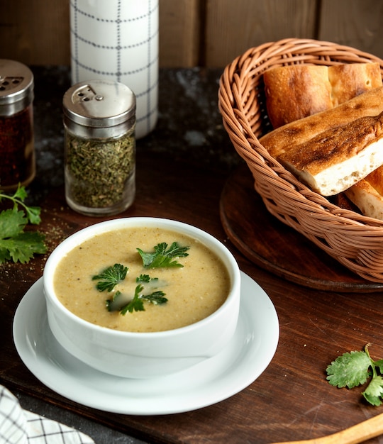Cremige Suppe und Korb mit Brot