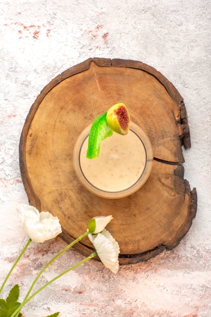 Cremiger Cocktail der Draufsicht in kleinem Glas mit Blumen auf weißem Schreibtischcocktailcreme-Farbfoto-Dessert