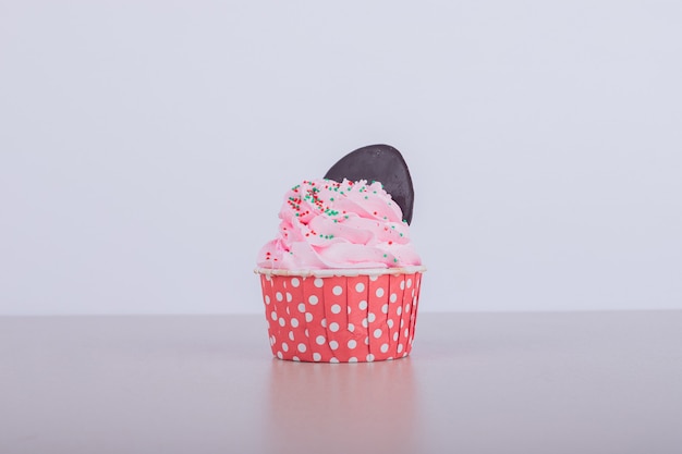 Kostenloses Foto cremiger rosa cupcake auf weiß