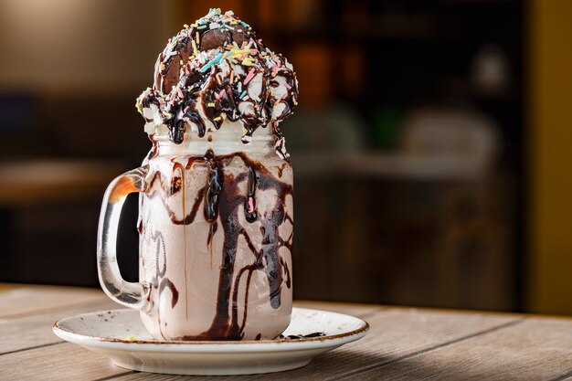 Cremiger Vanille-Milchshake mit Schokoladensauce in einer weißen Untertasse