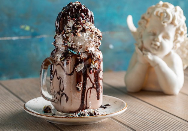 Cremiger Vanille-Milchshake mit Schokoladensauce in einer weißen Untertasse