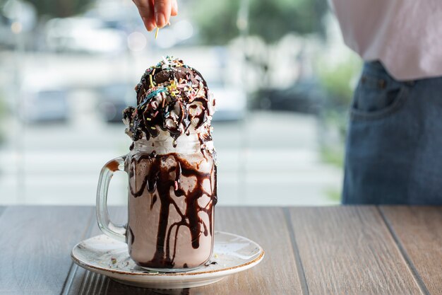 Cremiger Vanillemilchshake mit Schokoladensauce in einer weißen Untertasse