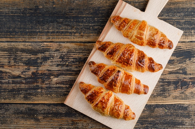 Croissant auf Holz und Schneidebrett. flach liegen.